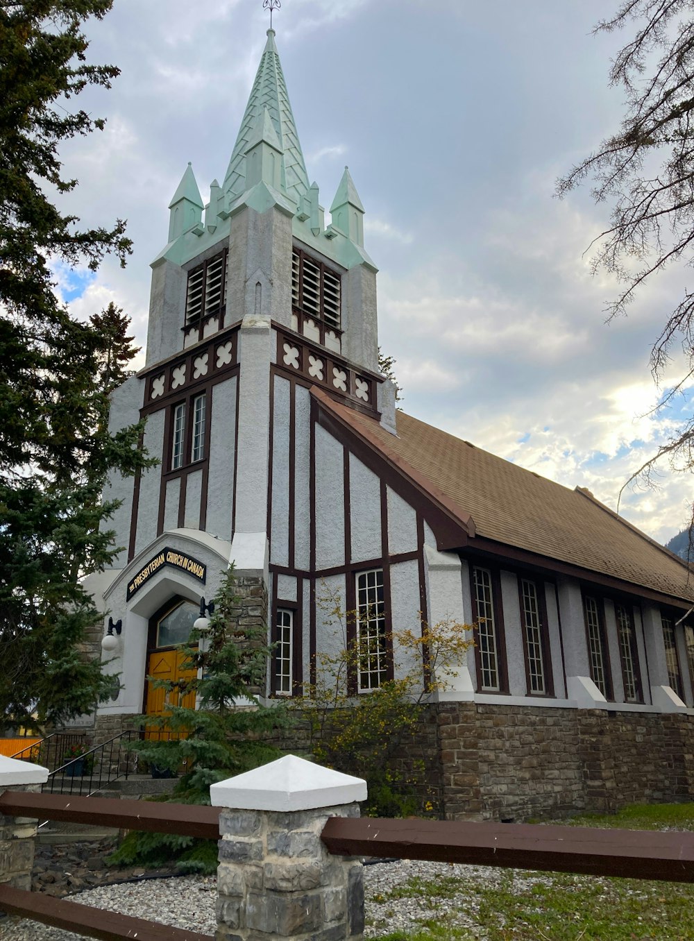 a church with a steeple and a fence around it