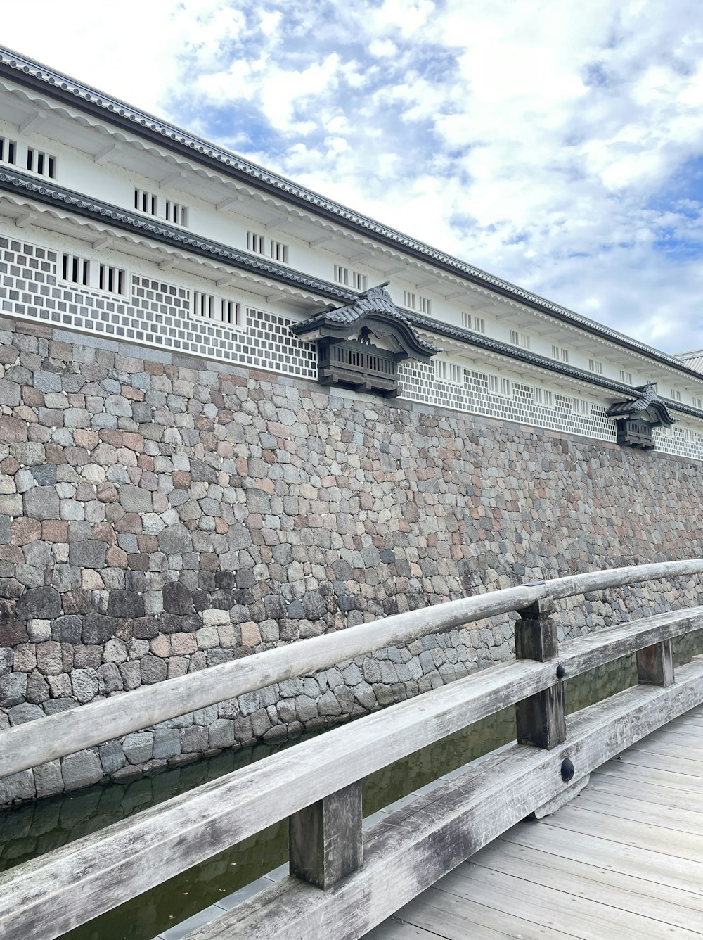 a stone wall next to a body of water