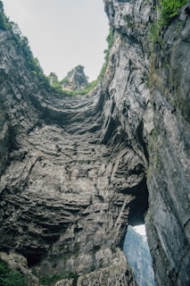 A breathtaking view of Pravčická brána, the iconic natural sandstone arch surrounded by lush green forest.