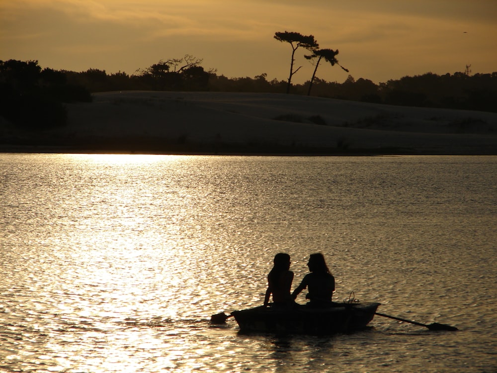 two people in a small boat on a lake