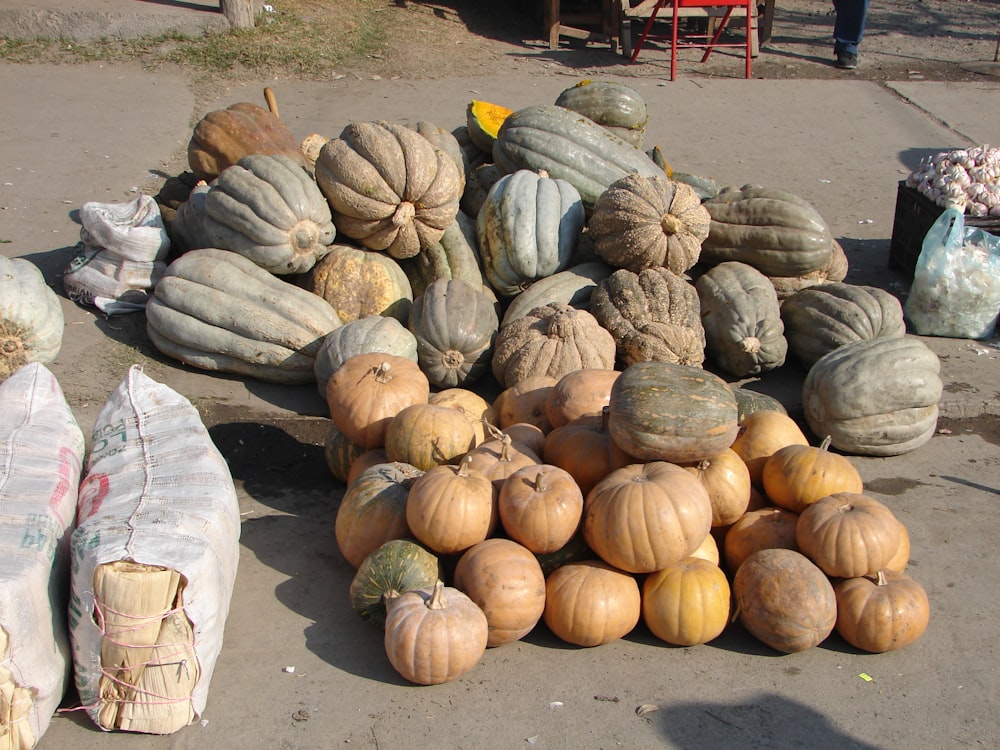 a pile of pumpkins and gourds sitting on the ground