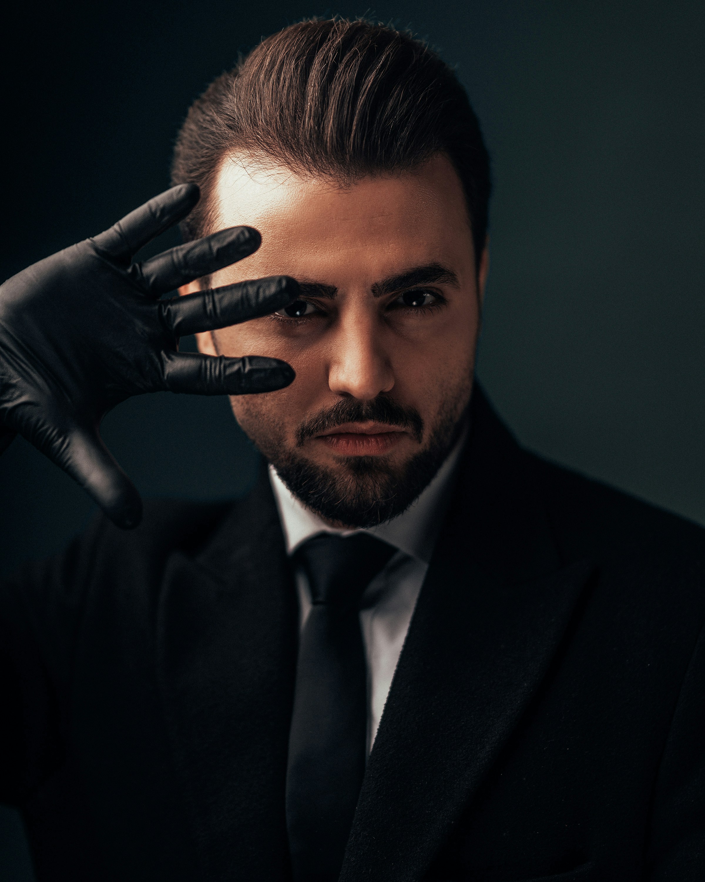 a man in a suit and tie holding his hand to his face