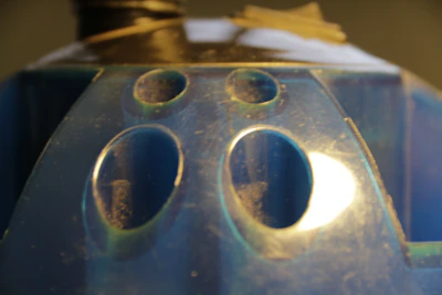 Close-up of a precision plastic mold with cobalt blue accents on a clean white surface.