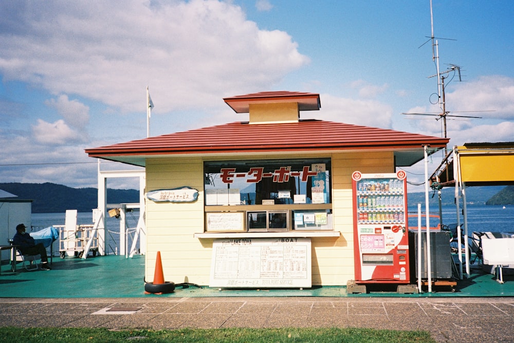 a small yellow building with a red roof