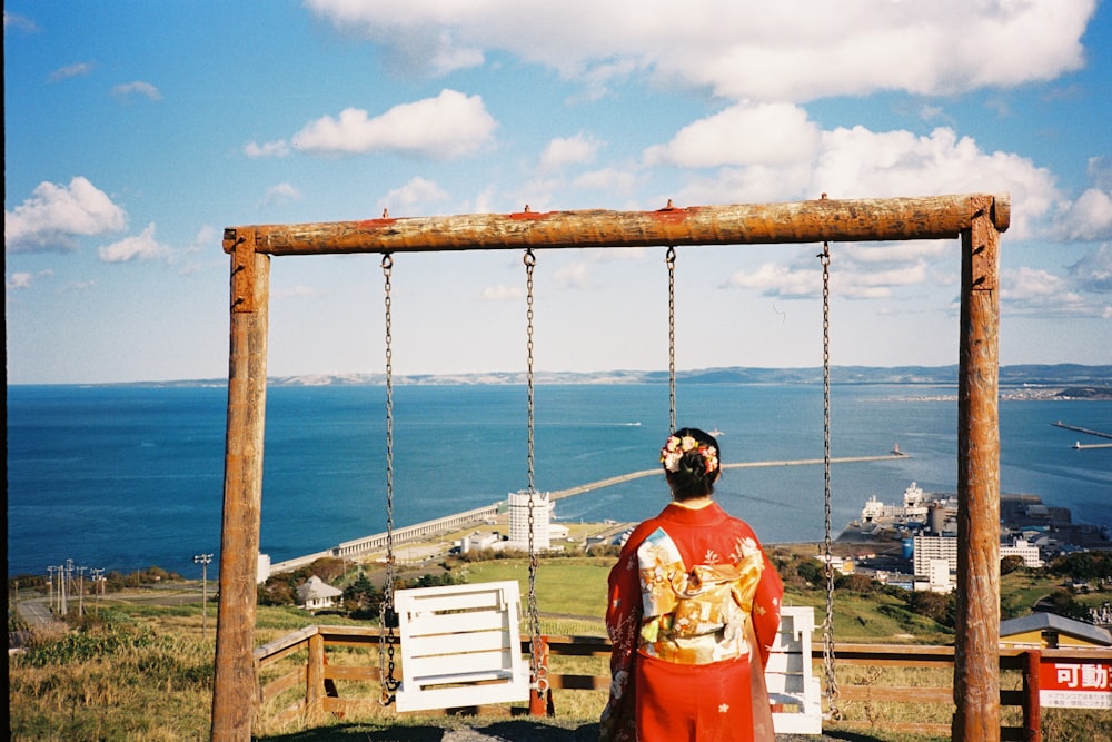 a man standing in front of a wooden swing