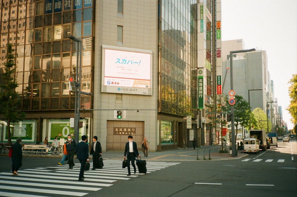 a group of people walking across a street