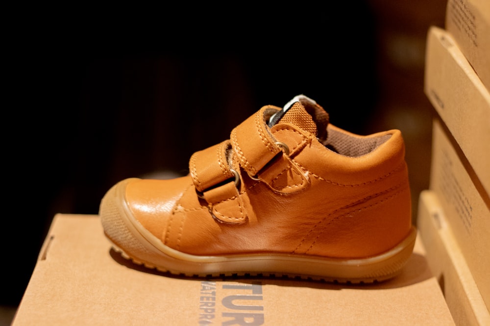 a pair of brown shoes sitting on top of a box