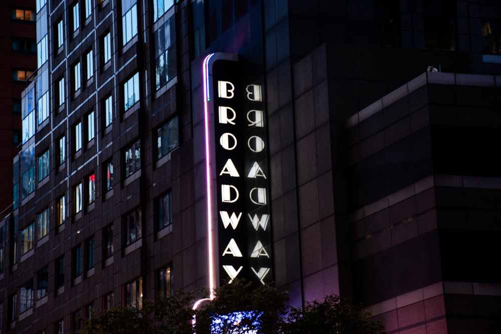 a tall building with a neon sign on it's side