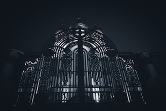 Close-up of a sleek custom metal gate with steel and gold accents under warm lighting.