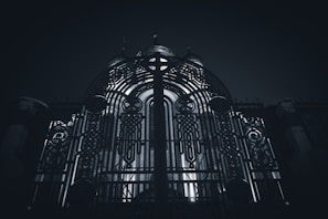 Close-up of a sleek custom metal gate with steel and gold accents under soft lighting.