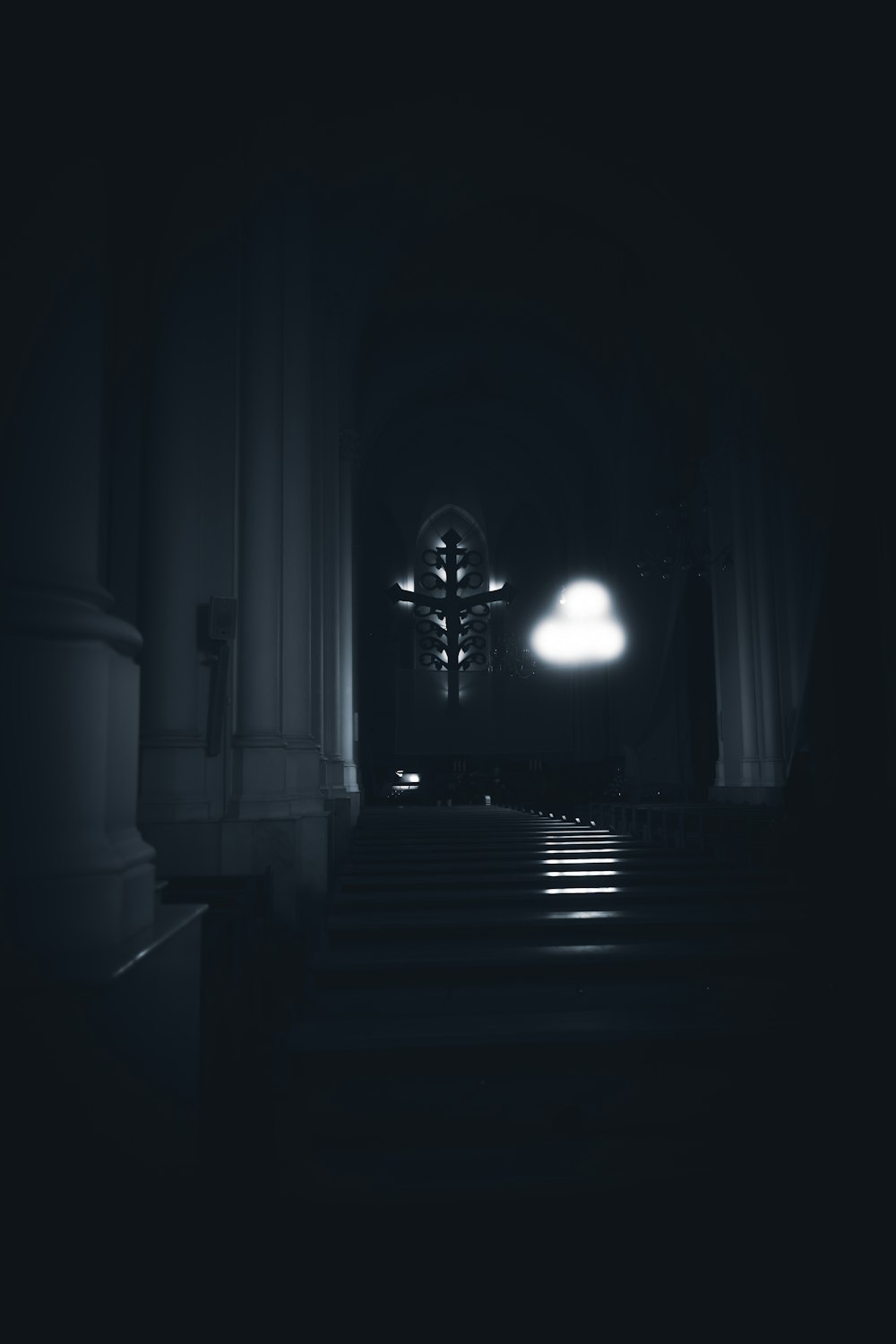 a dark hallway with a light at the end of it