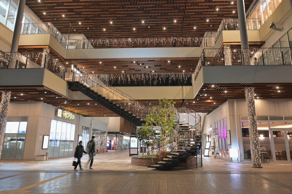 a couple of people walking inside of a building