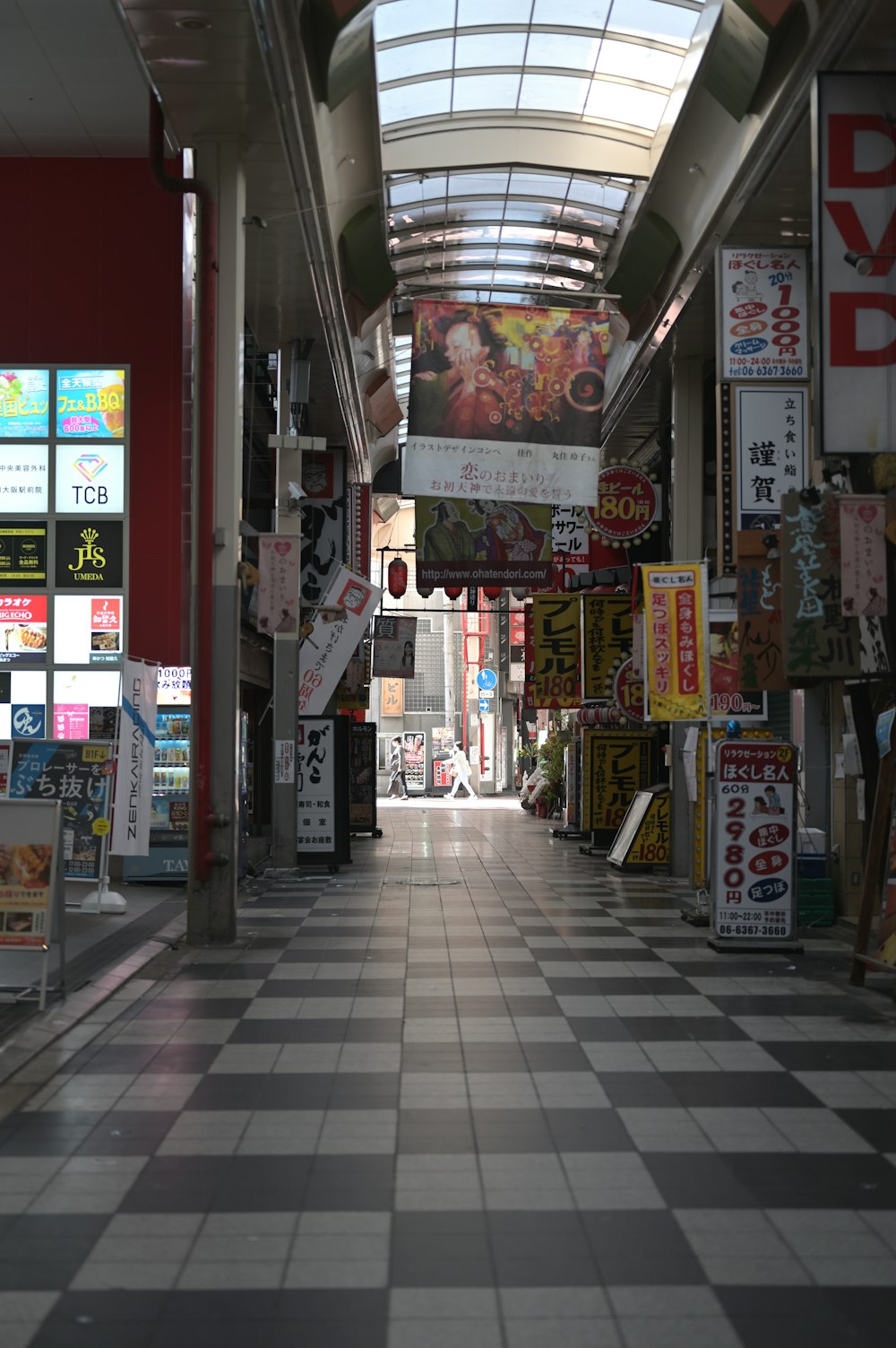 a long hallway with a checkered floor and a skylight