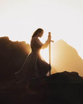 A powerful image of a warrior kneeling, holding a sword and shield.