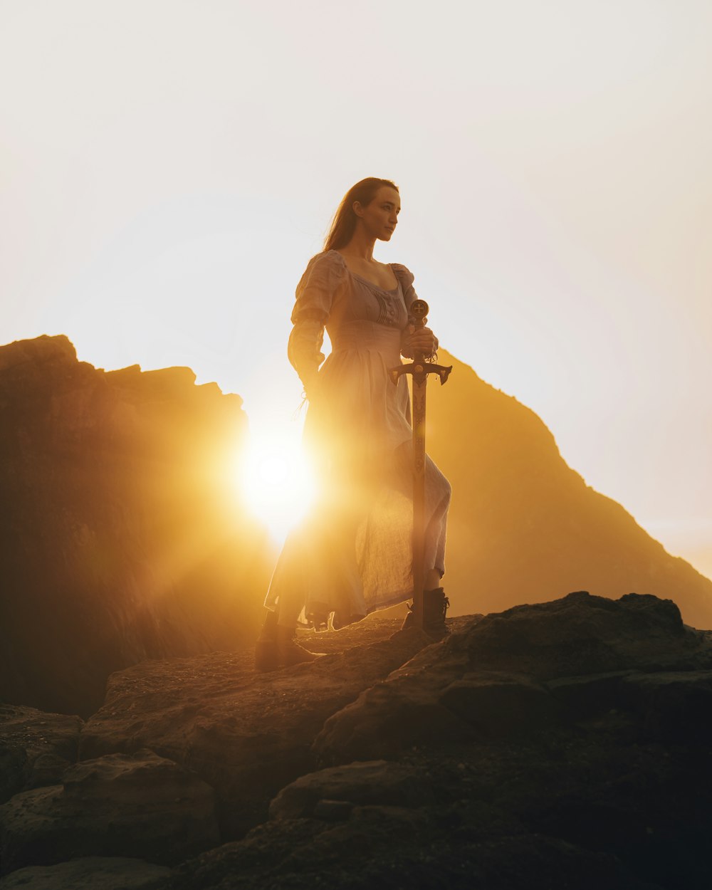 a woman standing on top of a mountain holding a scooter