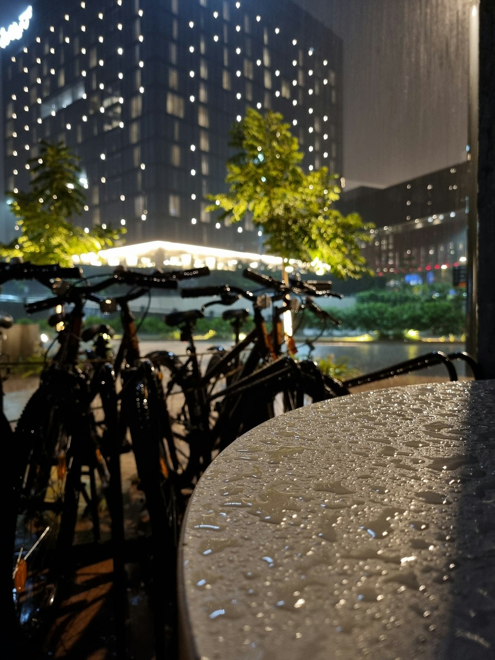 a table and some bikes in a city at night