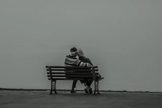 A soft watercolor portrait of an elderly couple sharing a quiet moment in a sunlit garden.