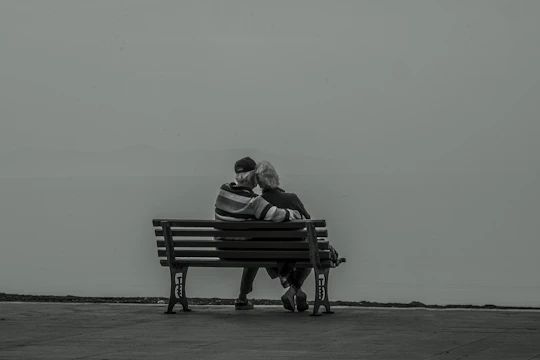 A soft watercolor portrait of an elderly couple sharing a quiet moment in a sunlit garden.