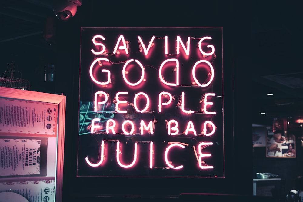 a neon sign that says saving good people from bad juice
