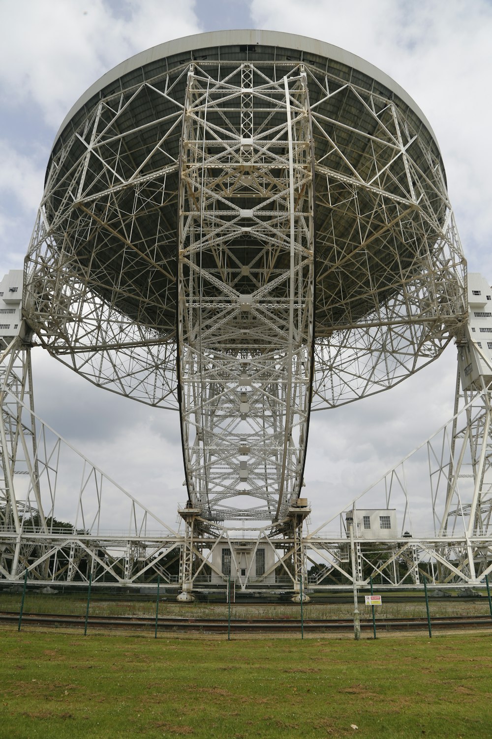 a large metal structure sitting on top of a lush green field