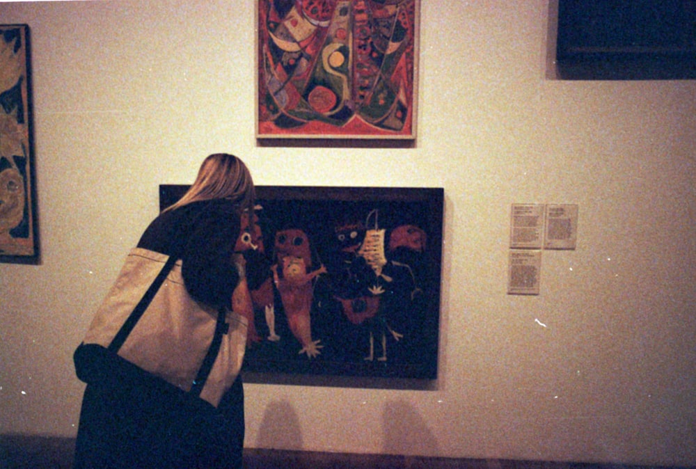 a woman looking at art on display in a museum