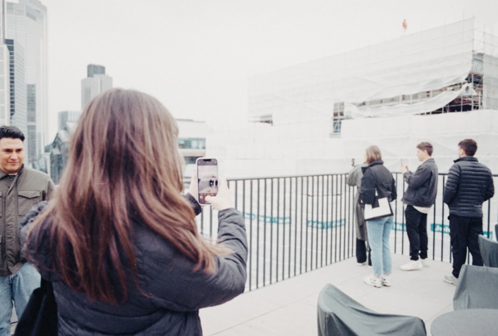 a woman taking a picture of a group of people