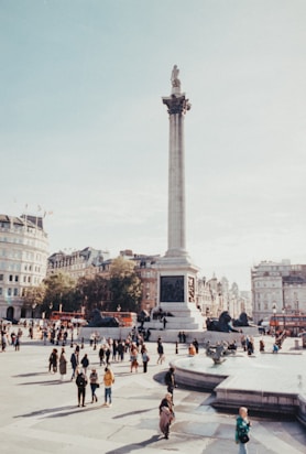 a group of people walking around a city square