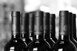 A close-up of assorted wine bottles on a wooden table.