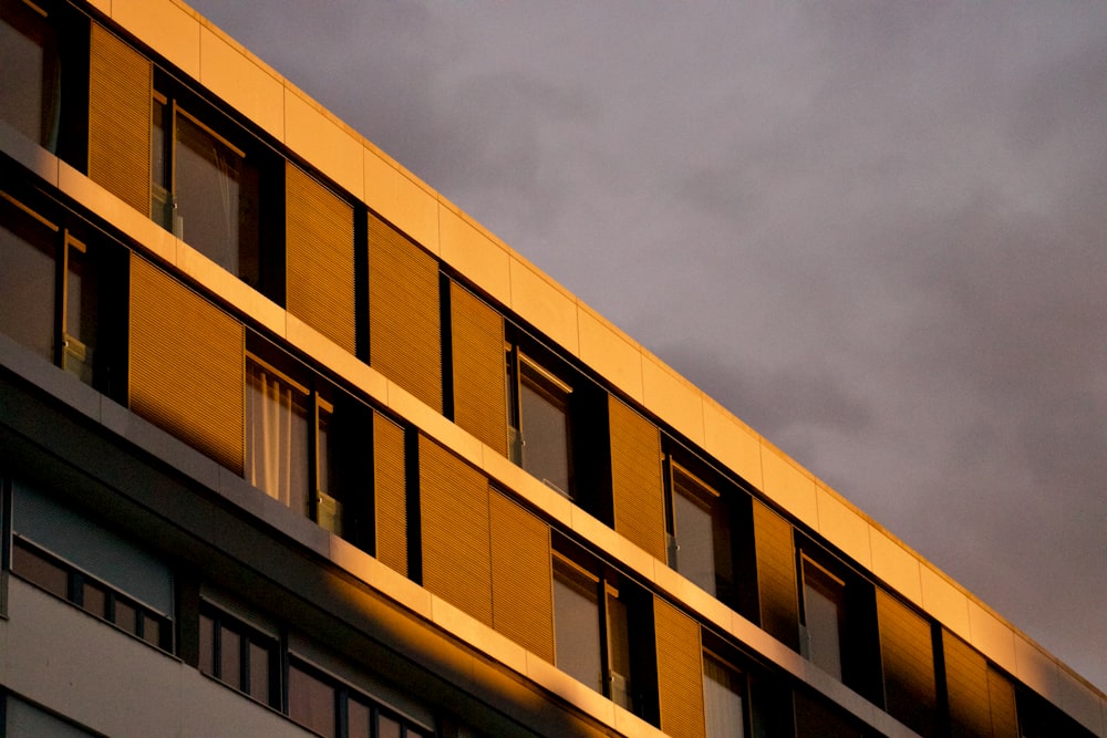 a tall building with windows and a sky in the background