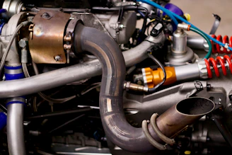 Close-up of a custom car exhaust system being carefully assembled in a workshop.