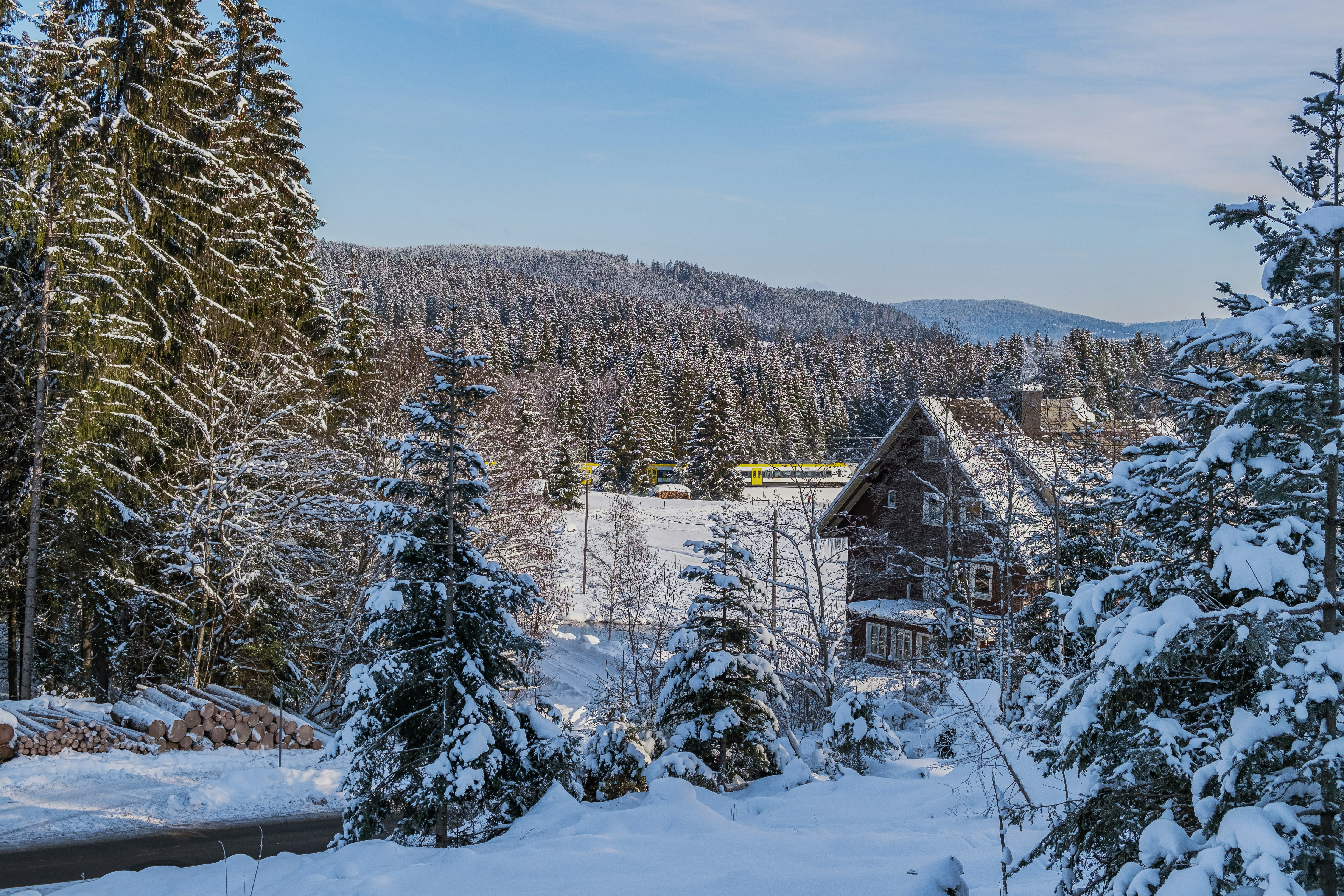 a house surrounded by snow covered trees in the mountains