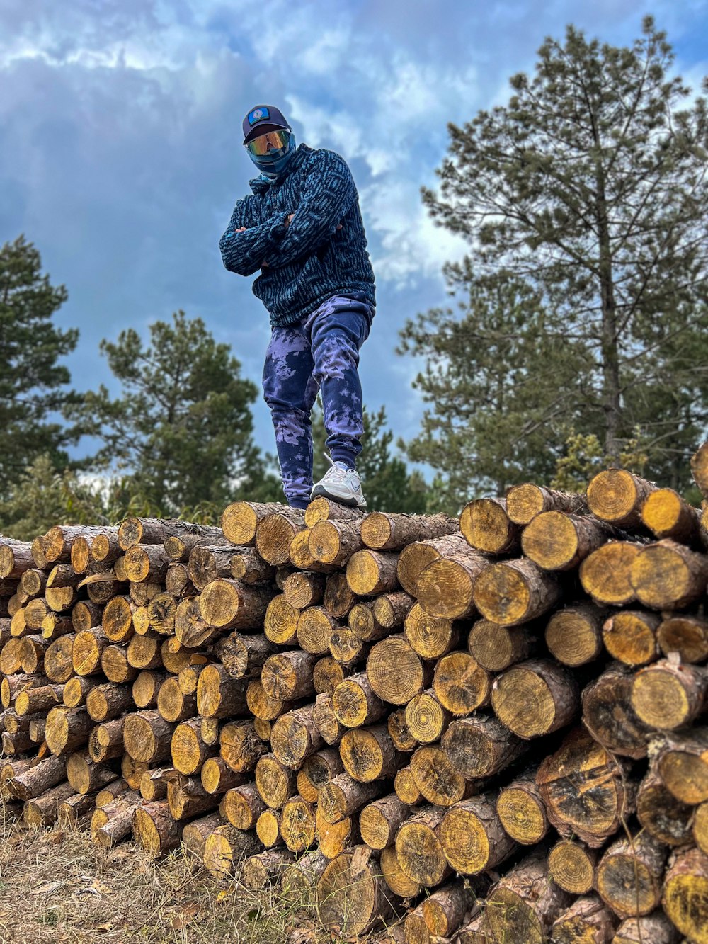 a man standing on top of a pile of logs