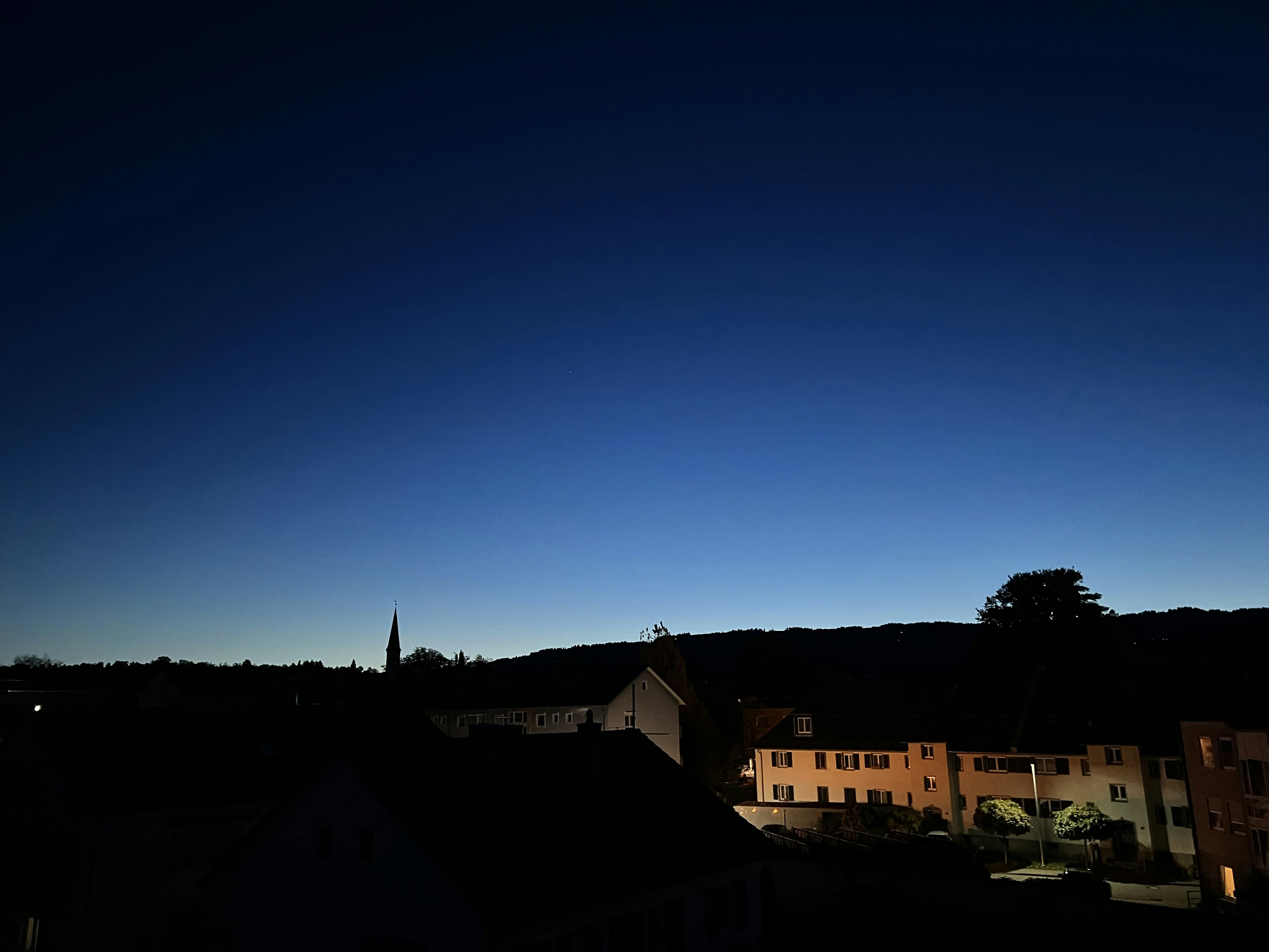 Blick auf eine Stadt bei Nacht von einem Dach