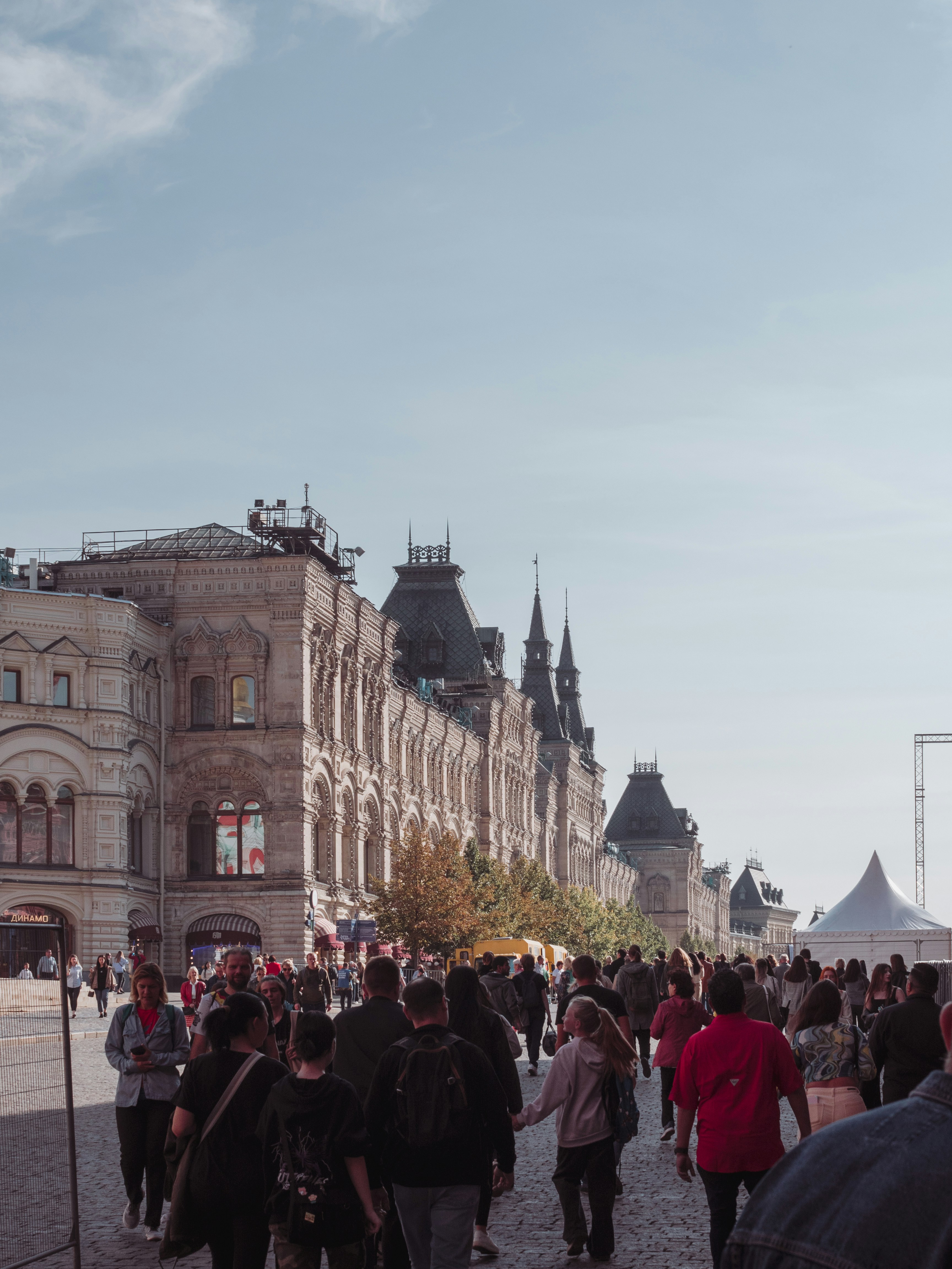 A crowd of people walking down a street next to tall buildings photo ...