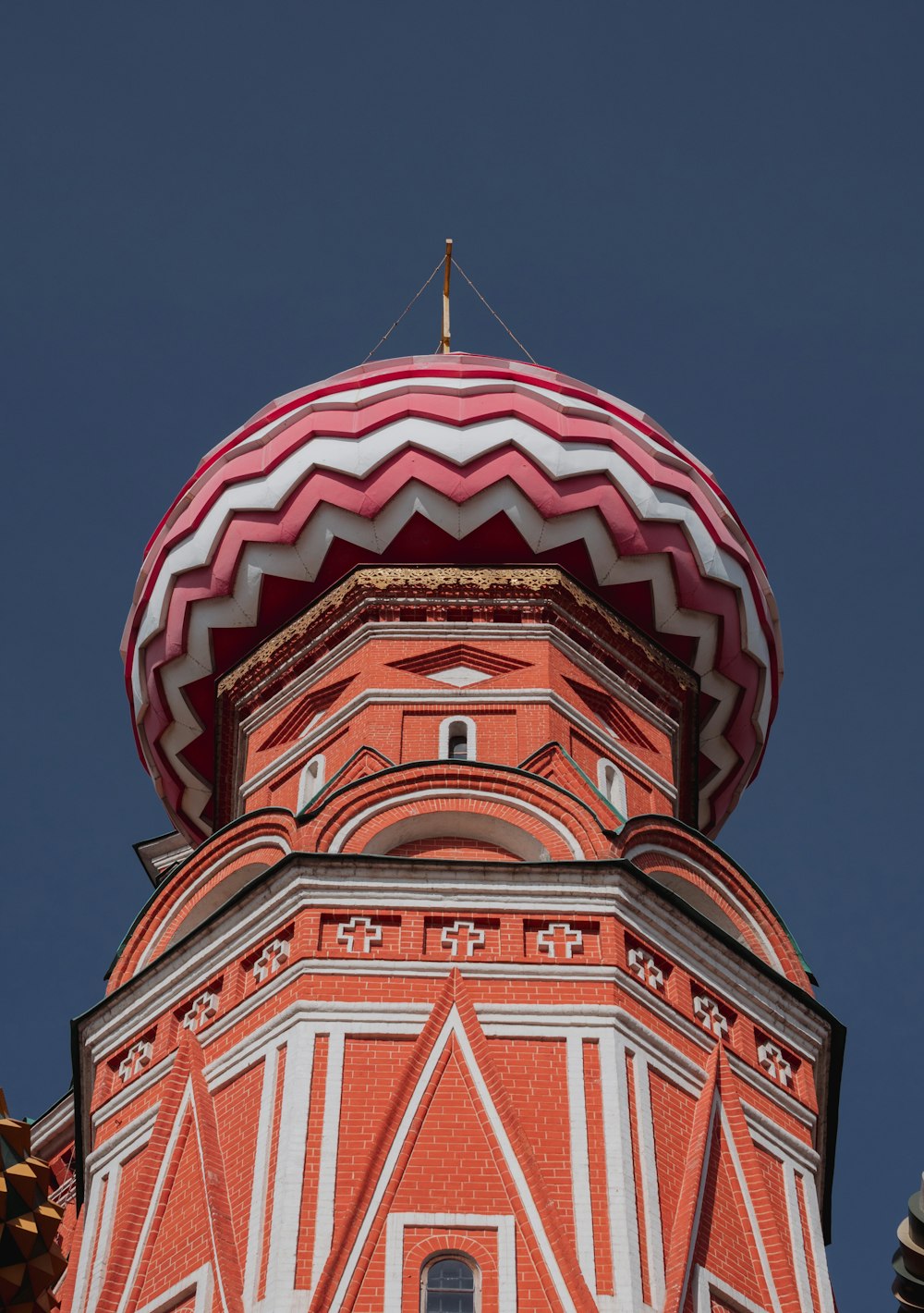 a tall red and white building with a red roof