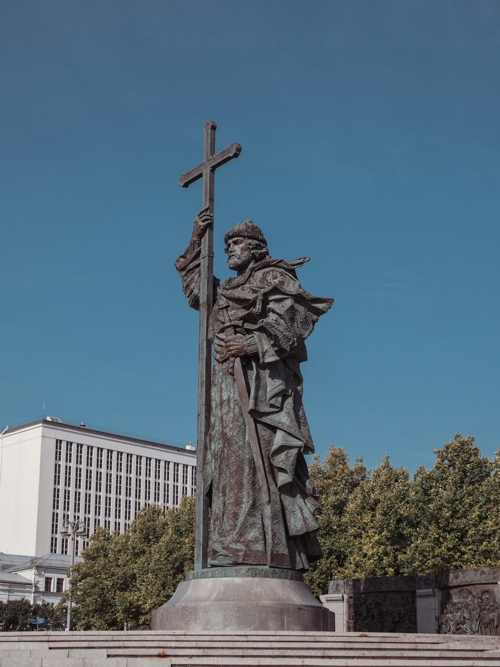 a statue of a man holding a cross