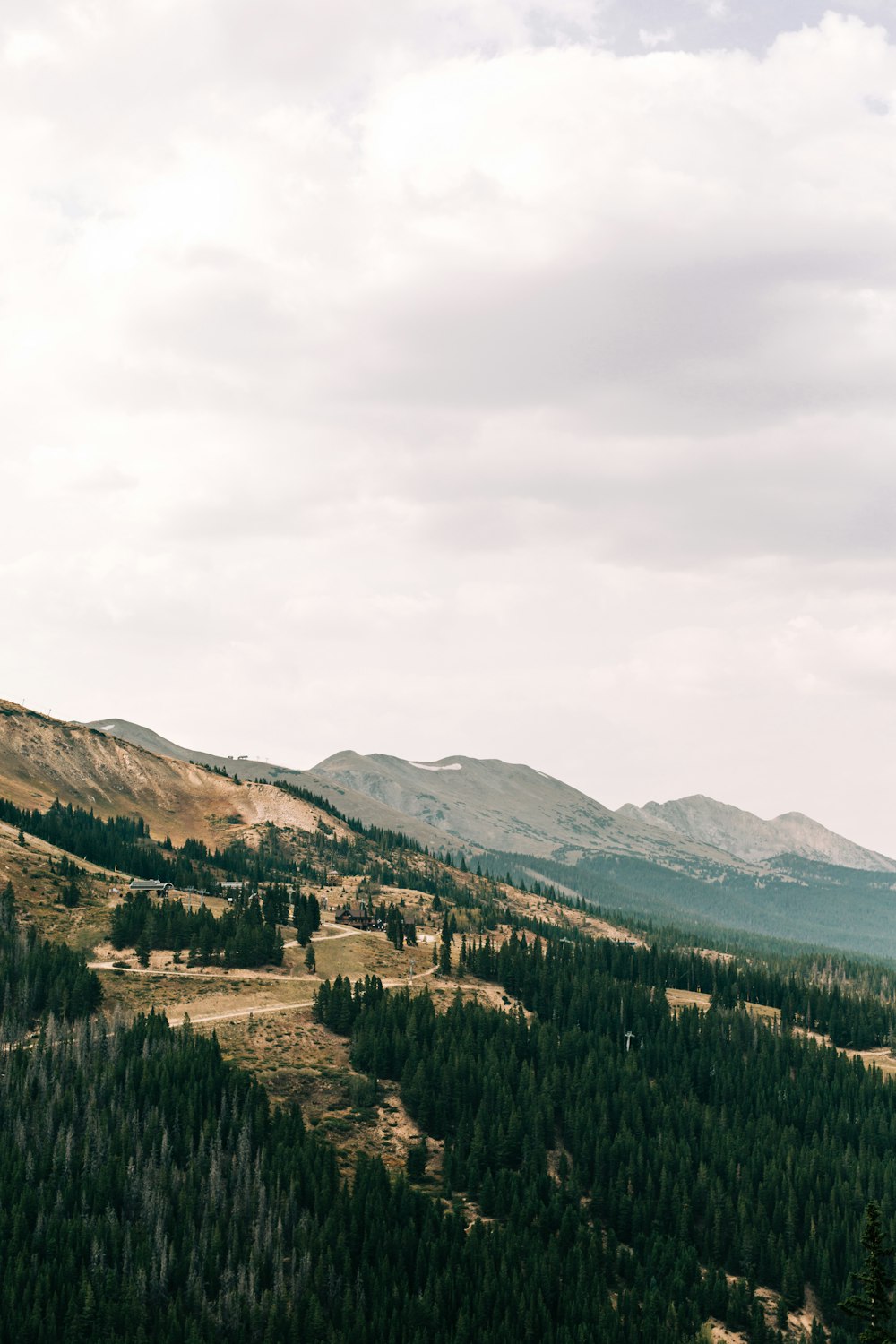 a scenic view of a mountain range with trees and mountains in the background