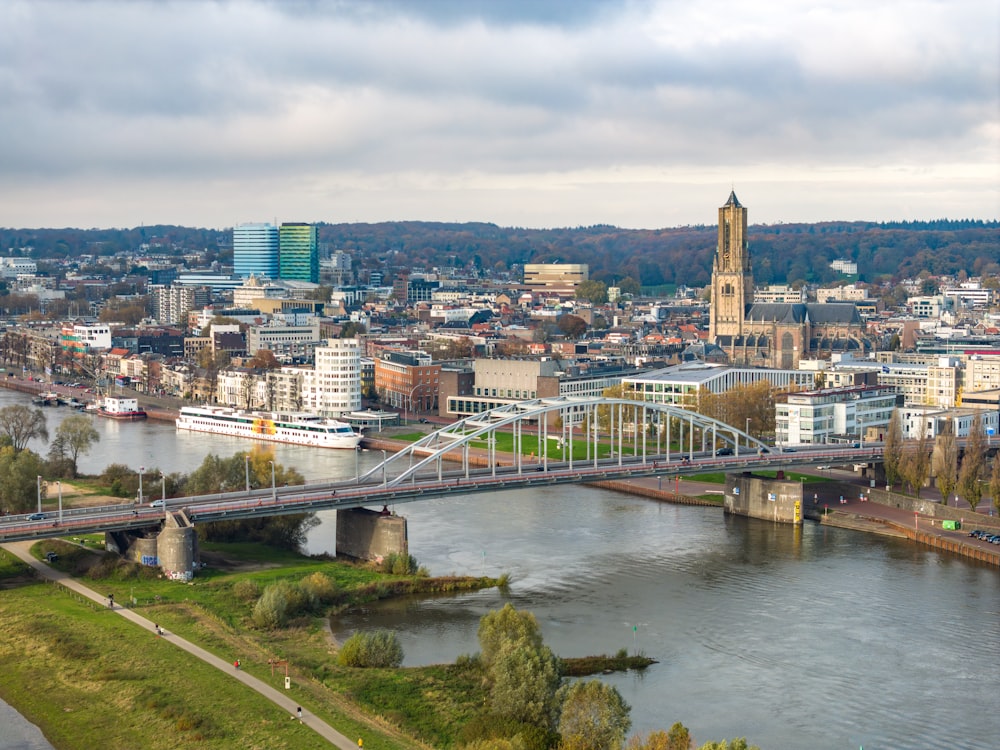 a bridge over a river with a city in the background