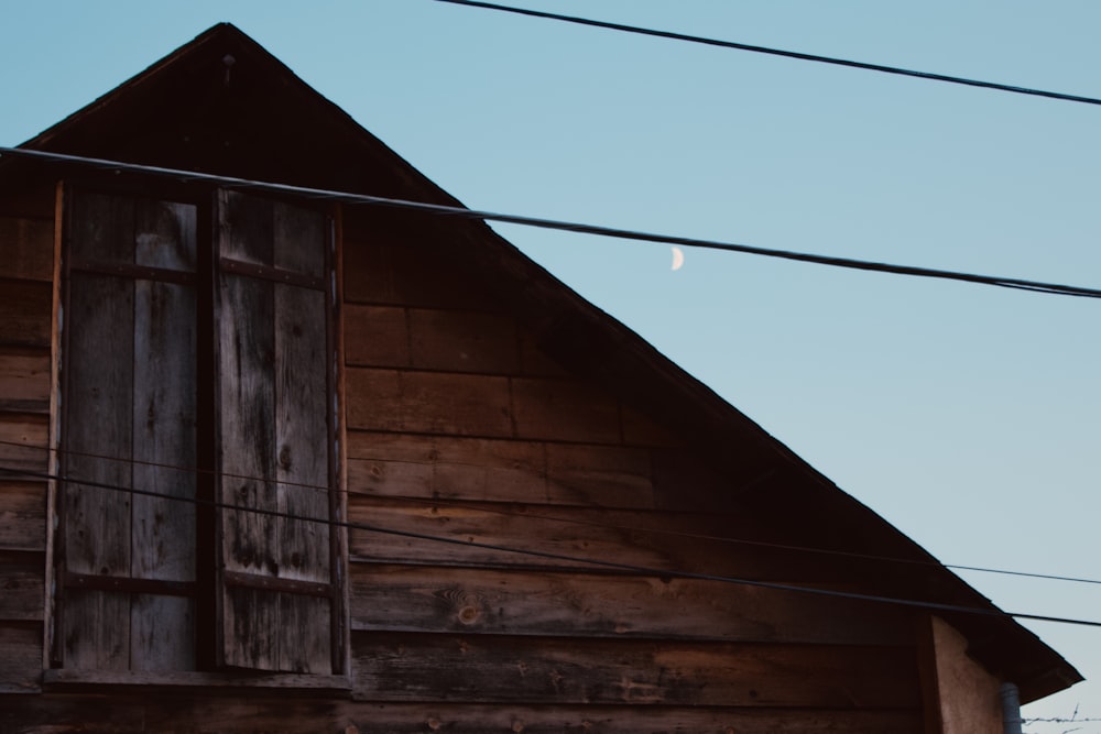 un viejo edificio de madera con una media luna en el cielo