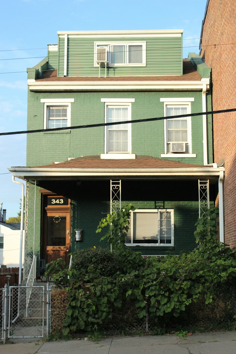 a green house with a red fire hydrant in front of it