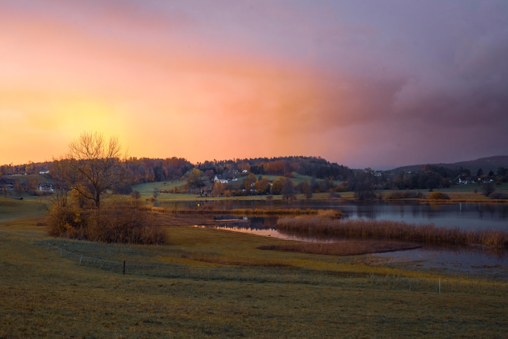 the sun is setting over a small lake