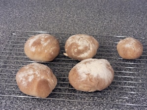 A freshly baked batch of artisanal rolls on a wooden table.