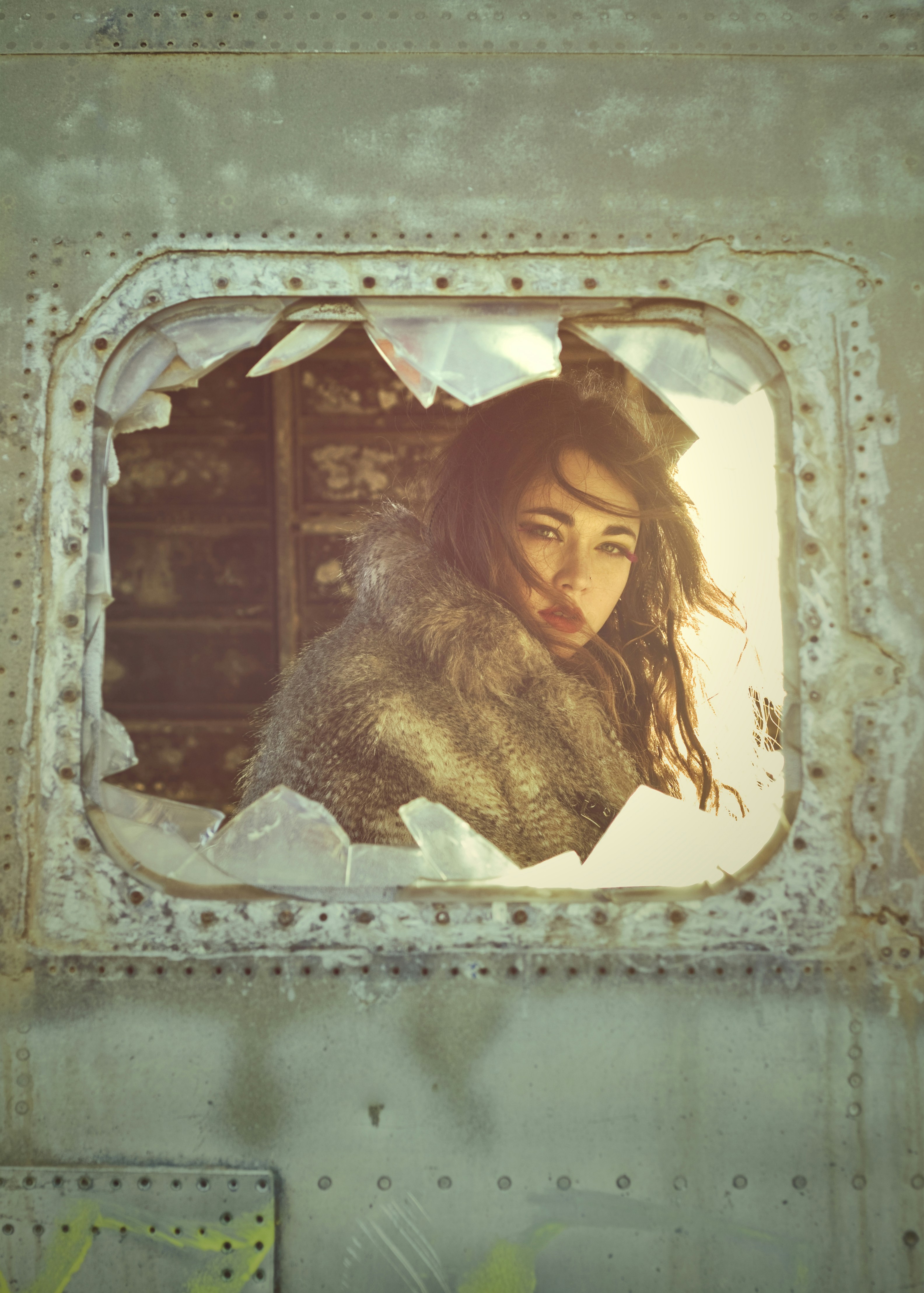 eine Frau, die durch ein Loch in der Seite eines Zuges schaut