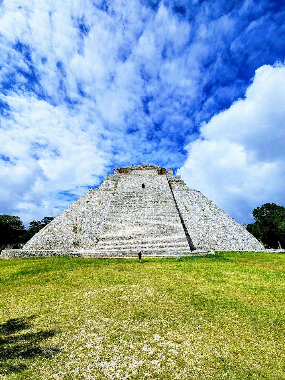 a large pyramid sitting on top of a lush green field