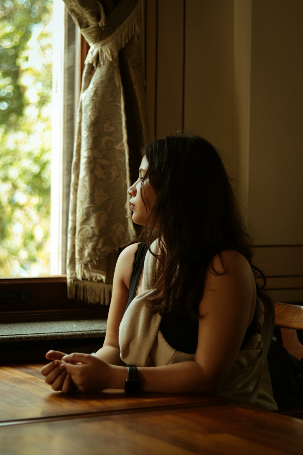 a woman sitting on the floor in front of a window