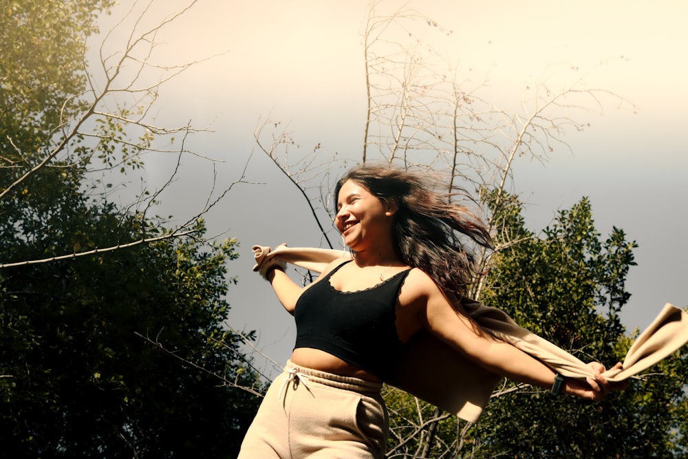 a woman in a black top is holding a frisbee