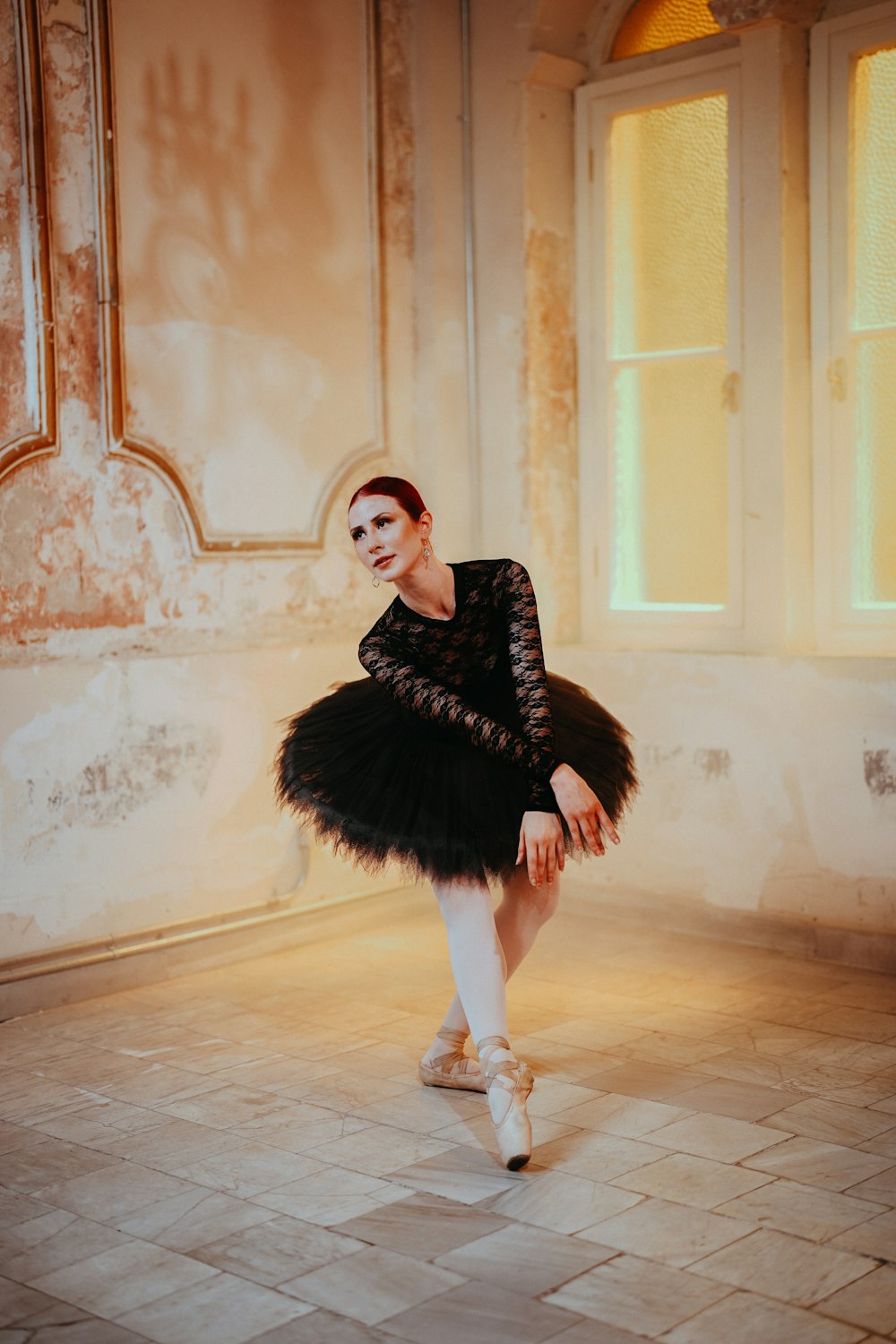 a ballerina in a black dress is posing for a picture