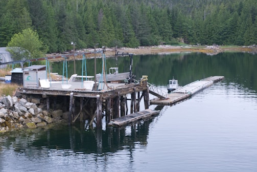 A dock extending into calm water with a sauna nearby.