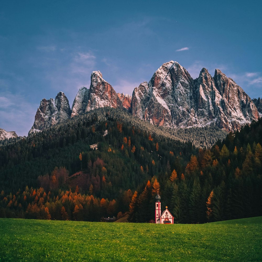 a church in a field with mountains in the background