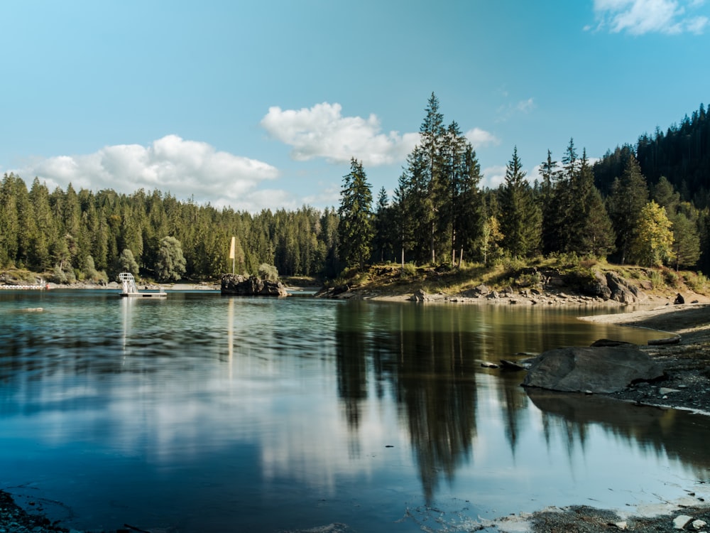 a boat on a lake surrounded by trees